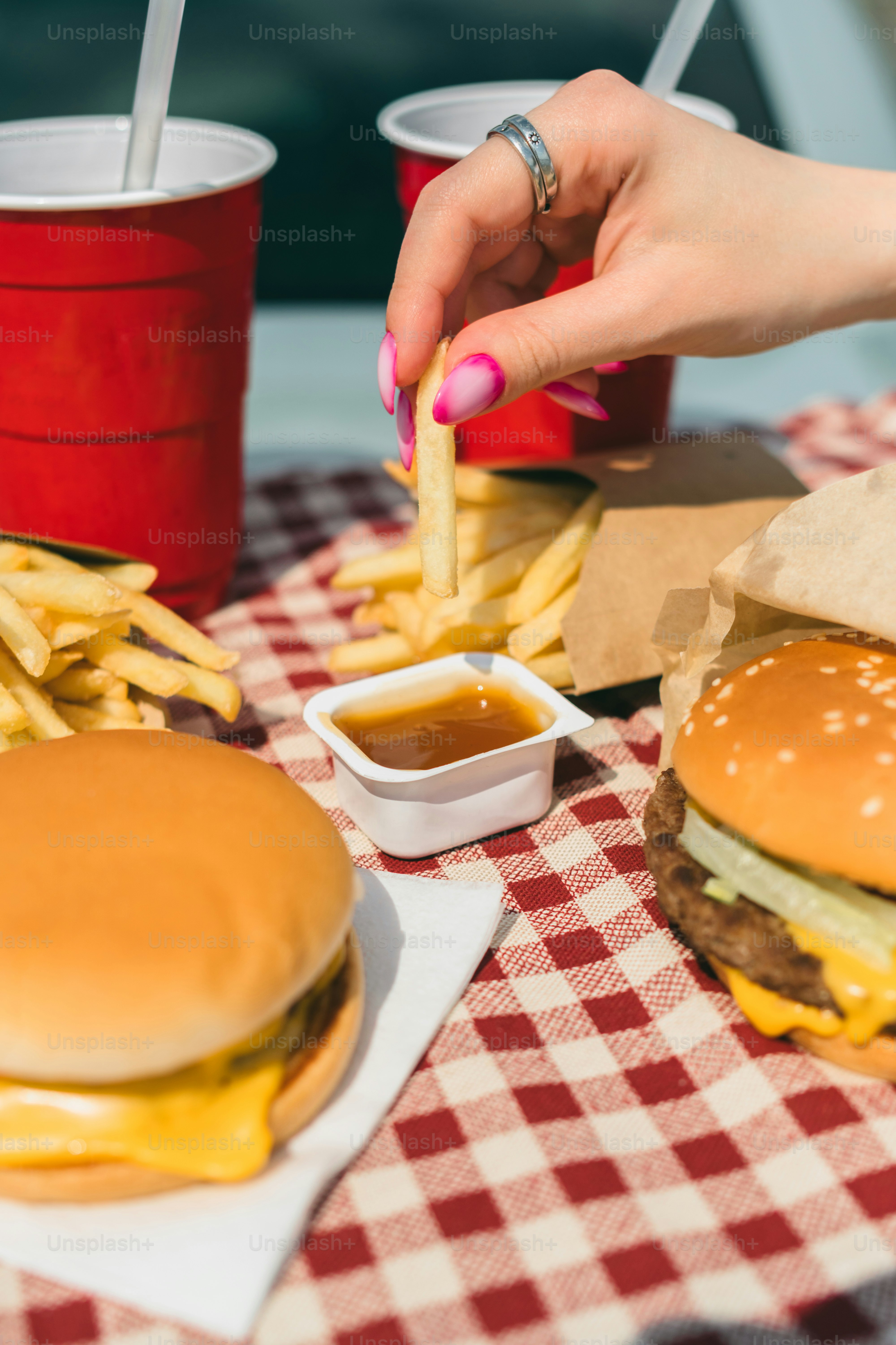 a woman is eating a hamburger and french fries