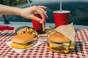 Eine Frau isst einen Hamburger und Pommes Frites