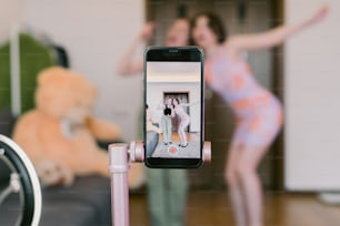 a person taking a picture of a woman in a pink dress