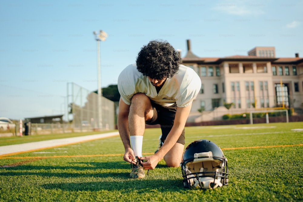 a football player tying his shoe before a game
