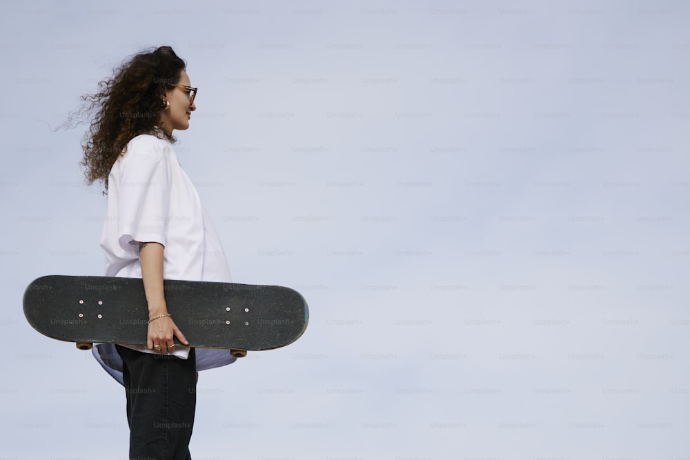 a woman holding a skateboard in her hands