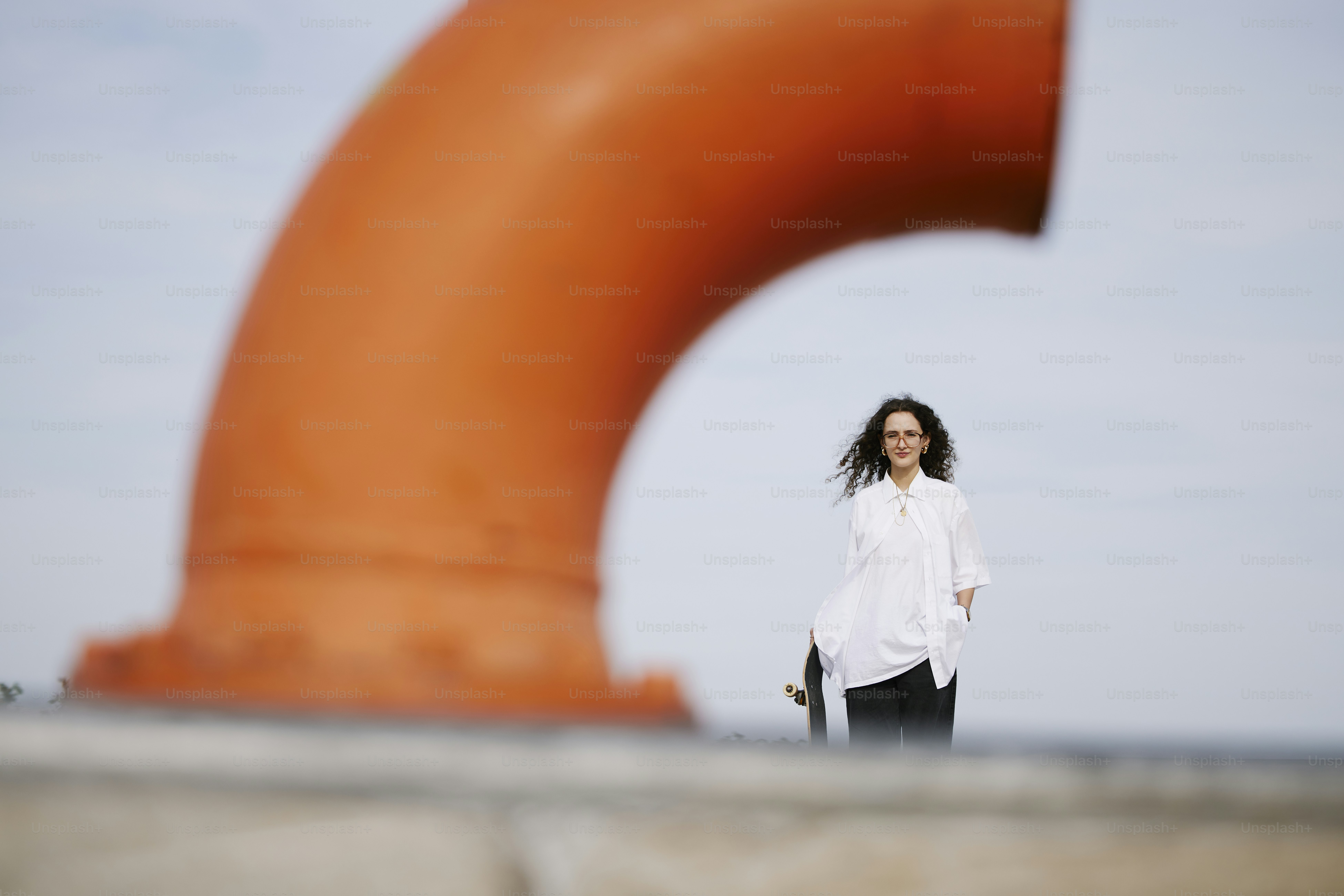 A woman standing in front of a large orange object photo – Outdoor ...