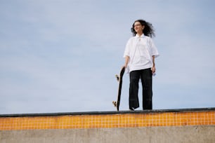 Una mujer sosteniendo una patineta en la parte superior de una rampa