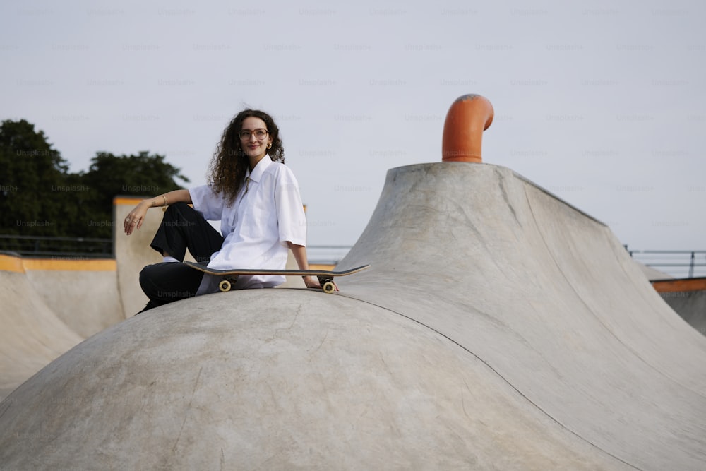 uma mulher sentada em cima de uma rampa de skate
