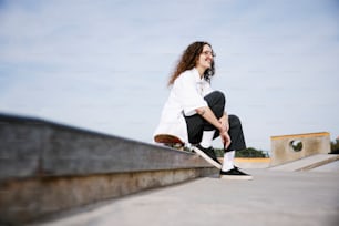 a person sitting on a ledge with a skateboard