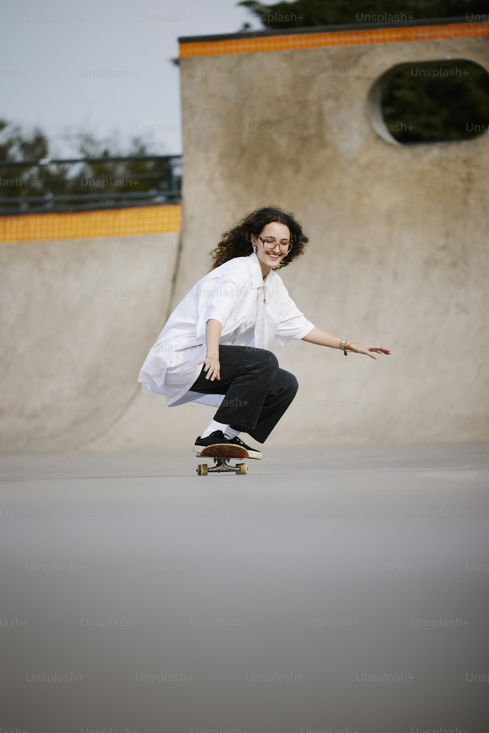 a woman riding a skateboard down the side of a ramp