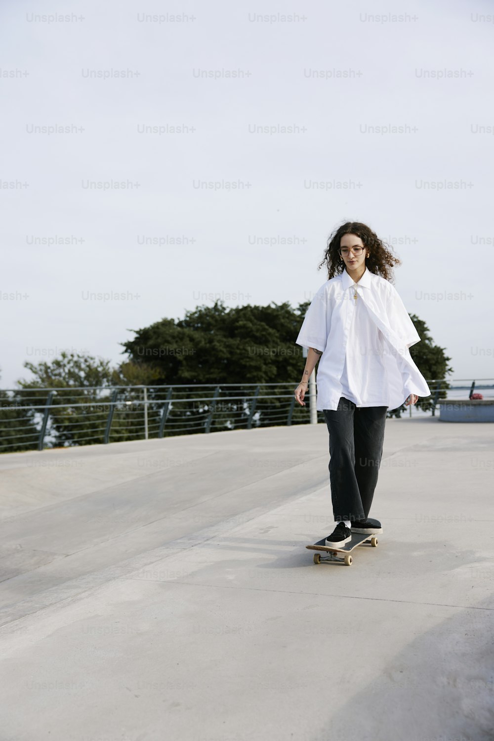 a woman riding a skateboard down a cement ramp