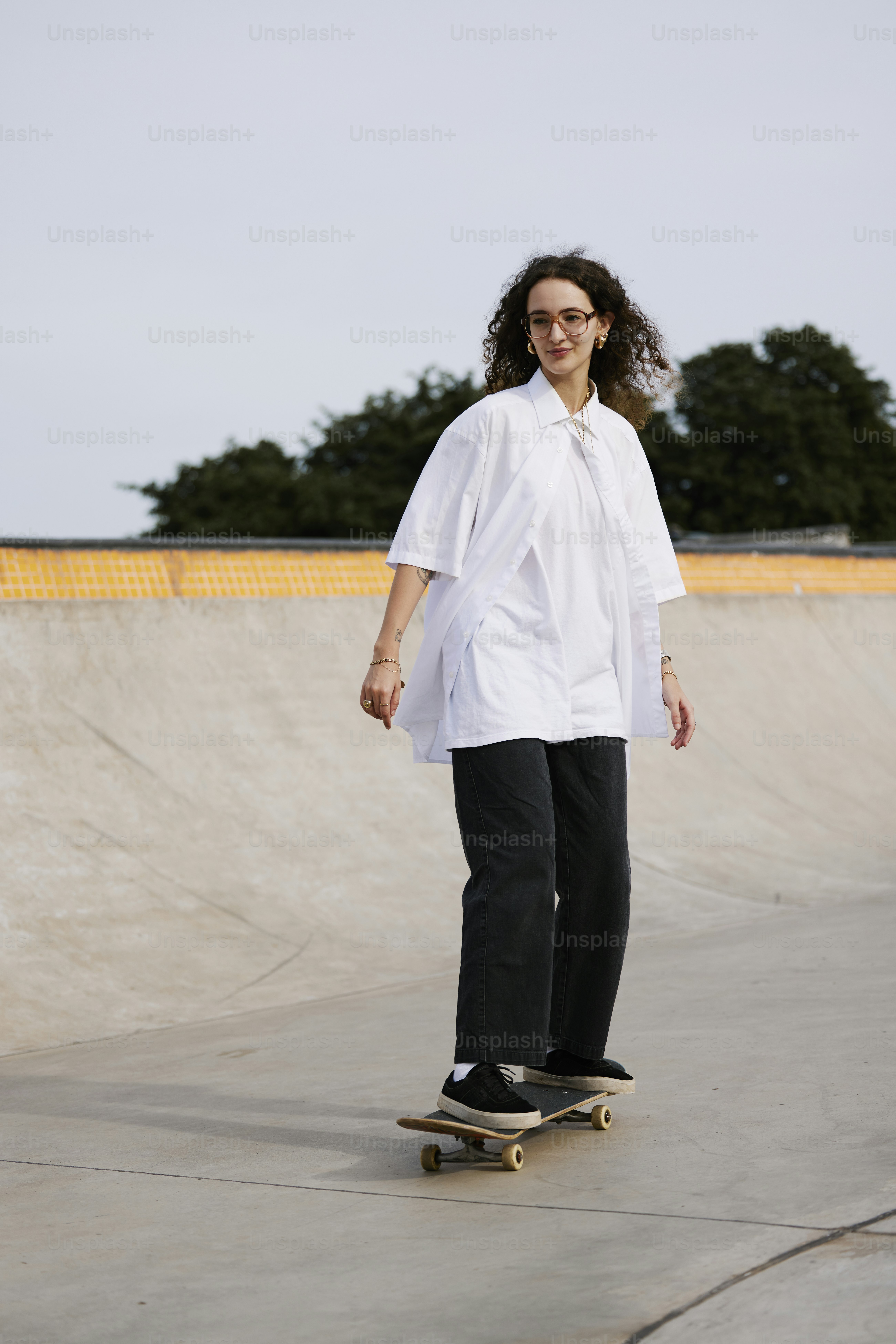 Una mujer montando una patineta en un parque de patinaje