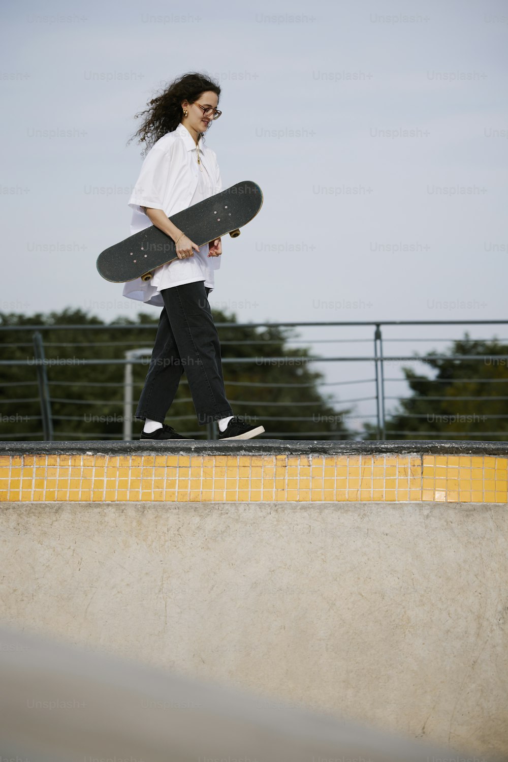 Un uomo che tiene uno skateboard mentre cammina su una rampa