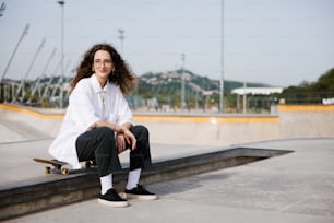 a woman sitting on a ledge with a skateboard