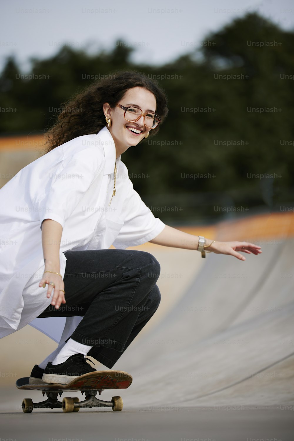 a woman riding a skateboard on top of a ramp