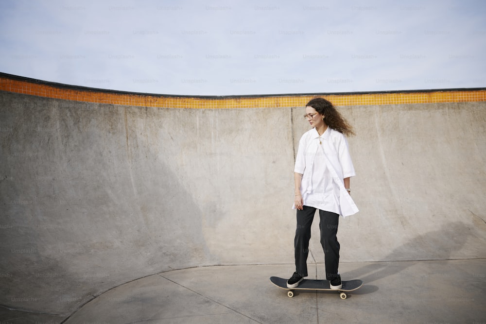 a woman standing on a skateboard in a skate park