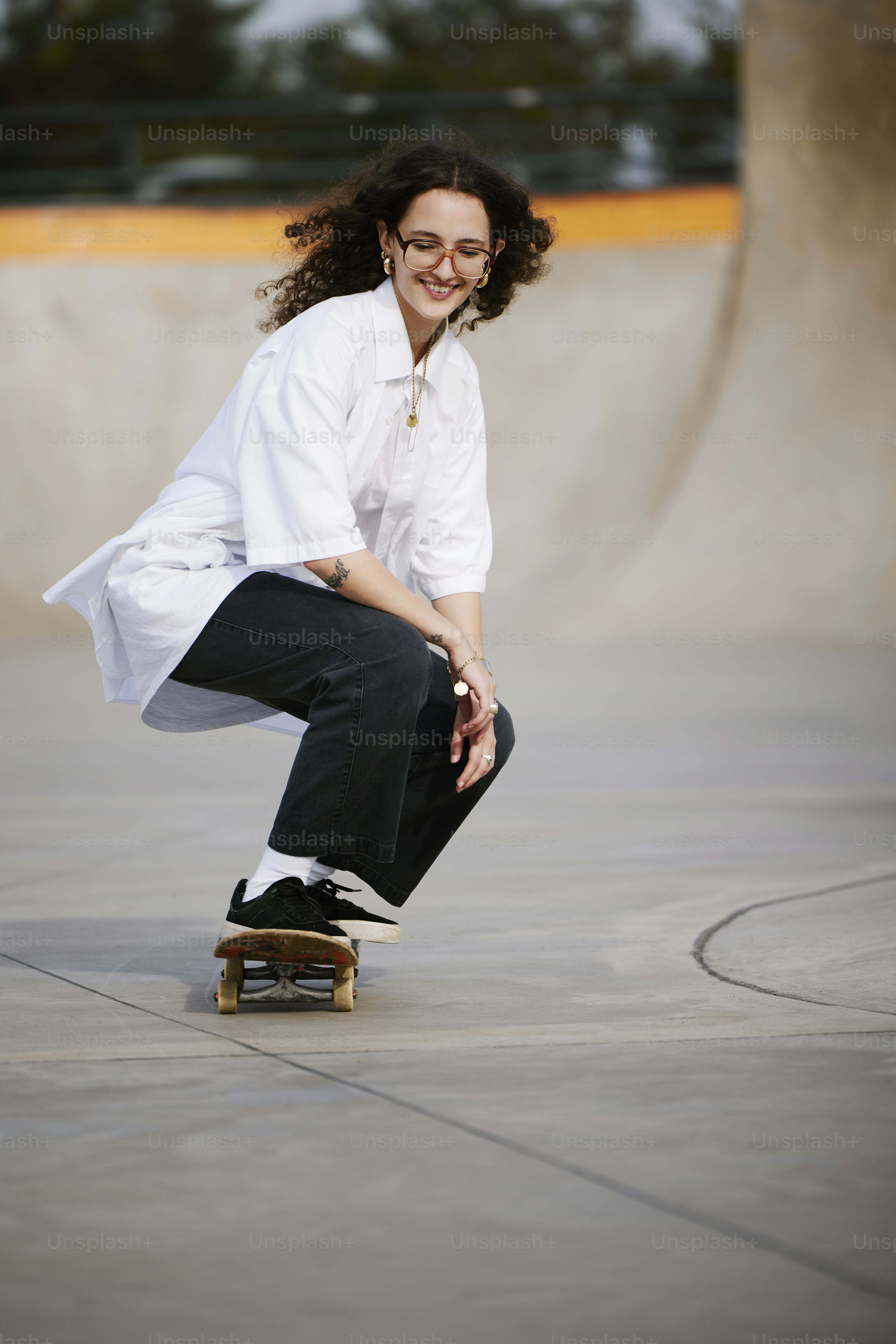 a woman riding a skateboard down a cement ramp