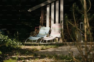 Un par de sillas de jardín sentadas una al lado de la otra