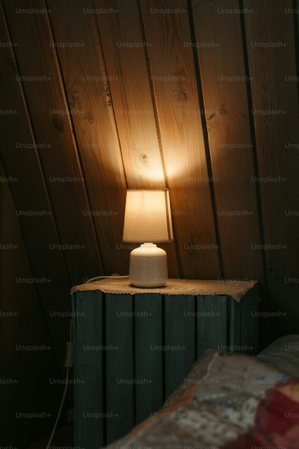 eine kleine Tischlampe, die auf einem Nachttisch sitzt
