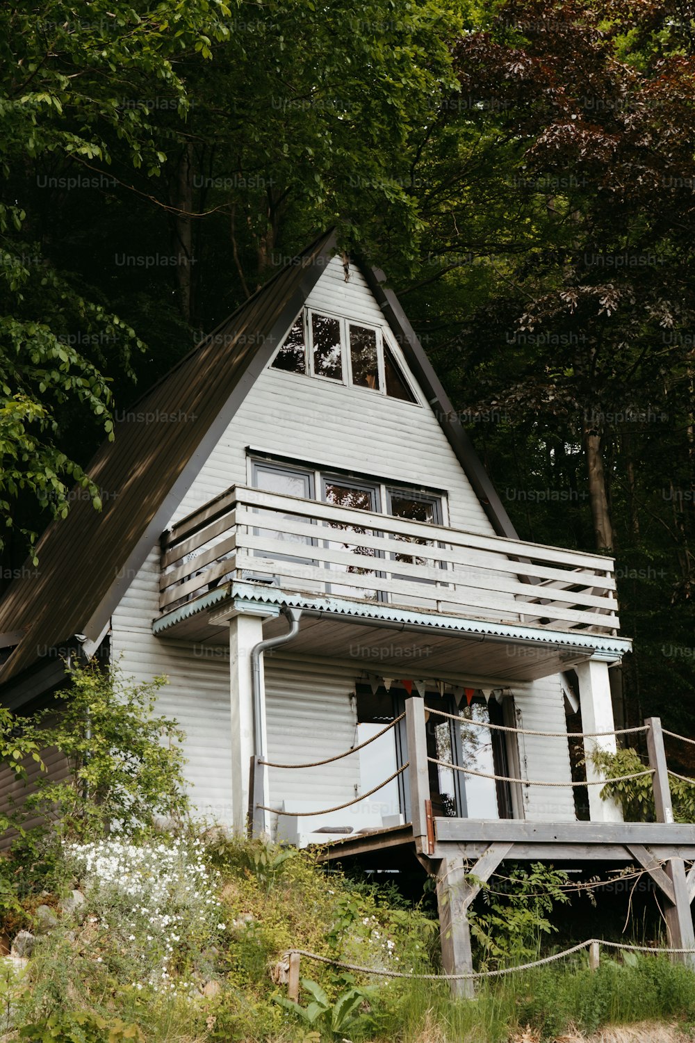 une maison blanche avec un porche et un balcon