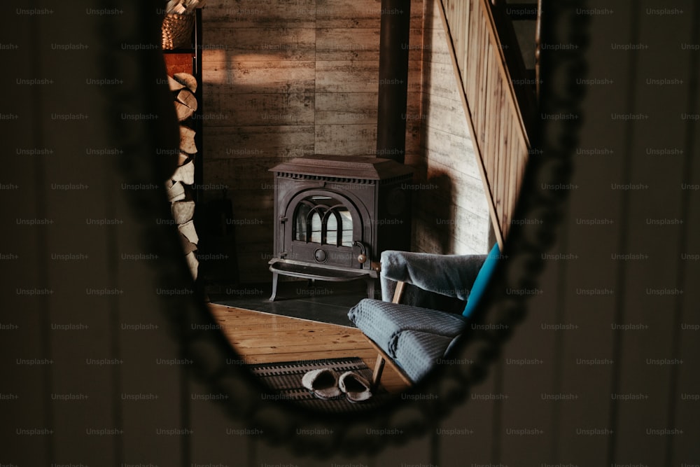 um espelho refletindo uma sala de estar com fogão a lenha