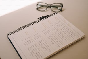 ein Kalender mit Gläsern auf einem Tisch neben einer Brille