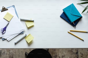 a white table topped with lots of office supplies