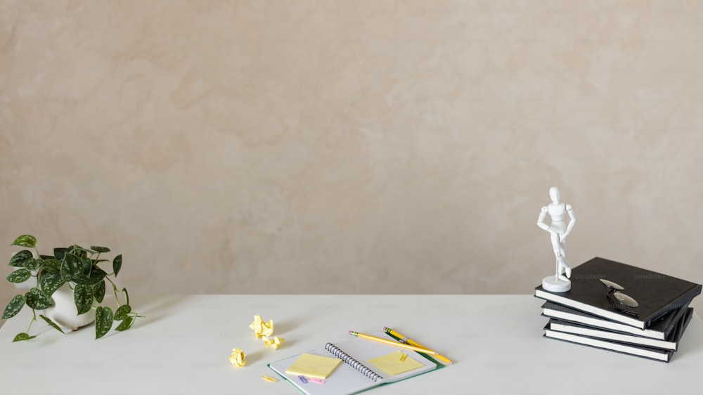 a desk with a book, notebook, and a statue