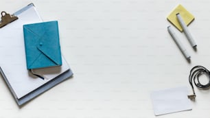 a white table topped with a notebook and a pen