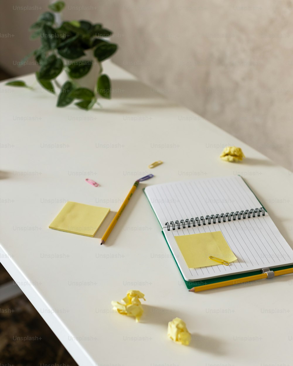 하얀 탁자 위에 놓인 메모장과 펜