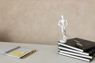 本の山とテーブルの上の彫像