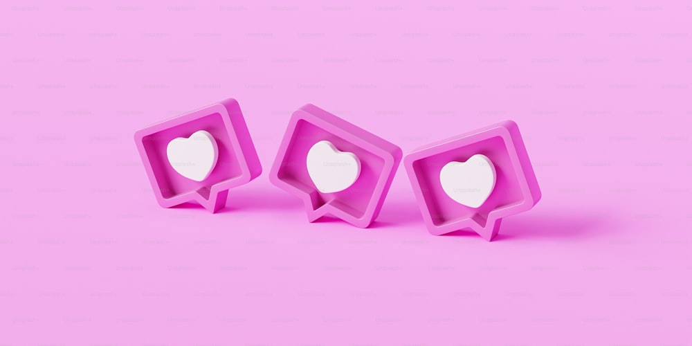 Un par de cortadores de galletas en forma de corazón sentados encima de una superficie rosada