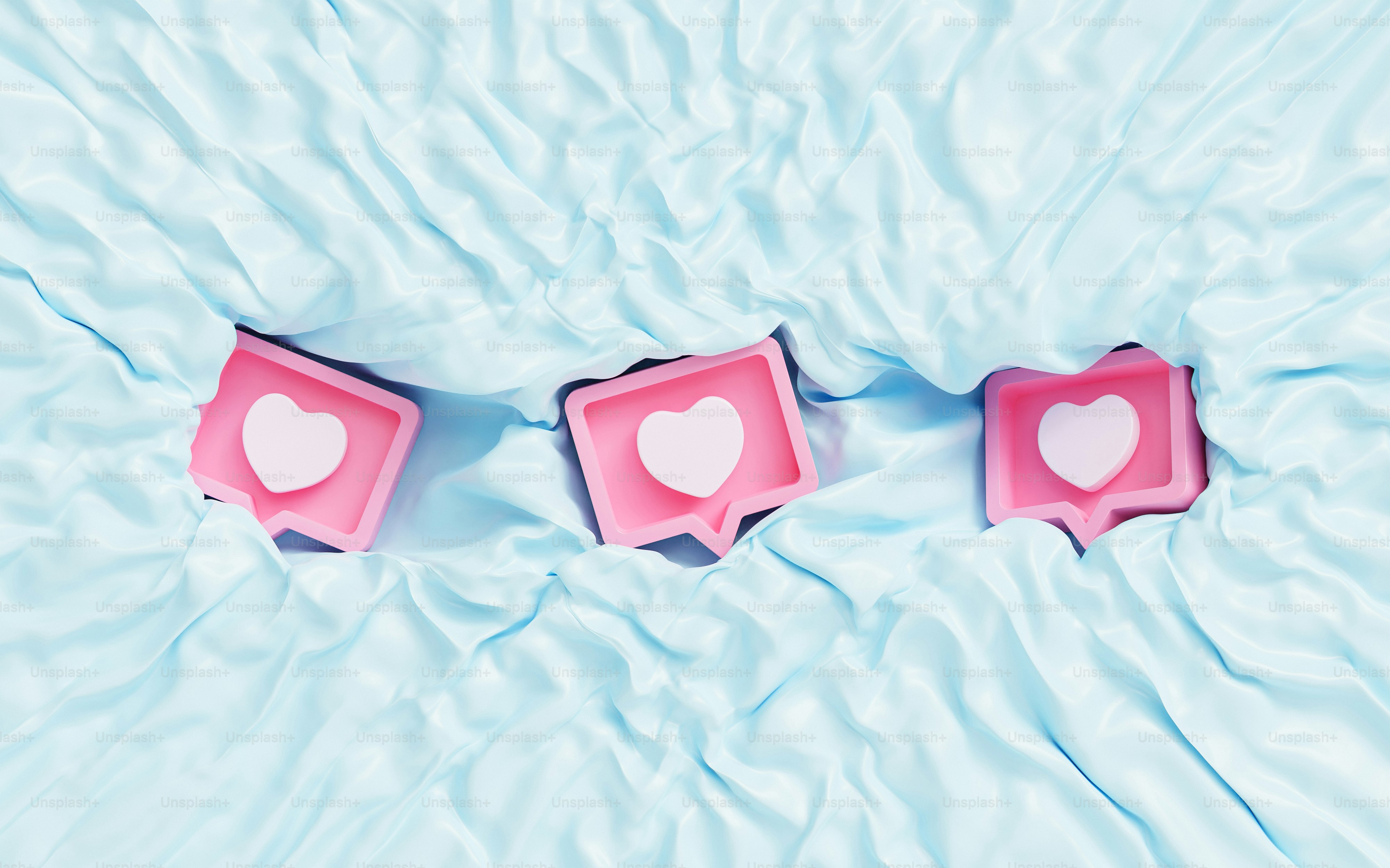 two heart shaped candles sitting on top of a blue sheet