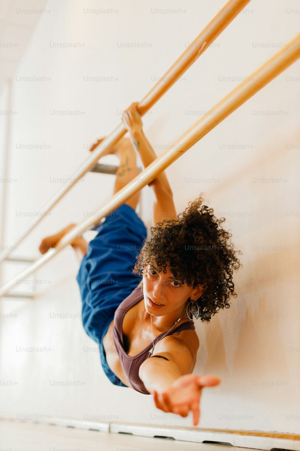 a woman hanging upside down on a pole
