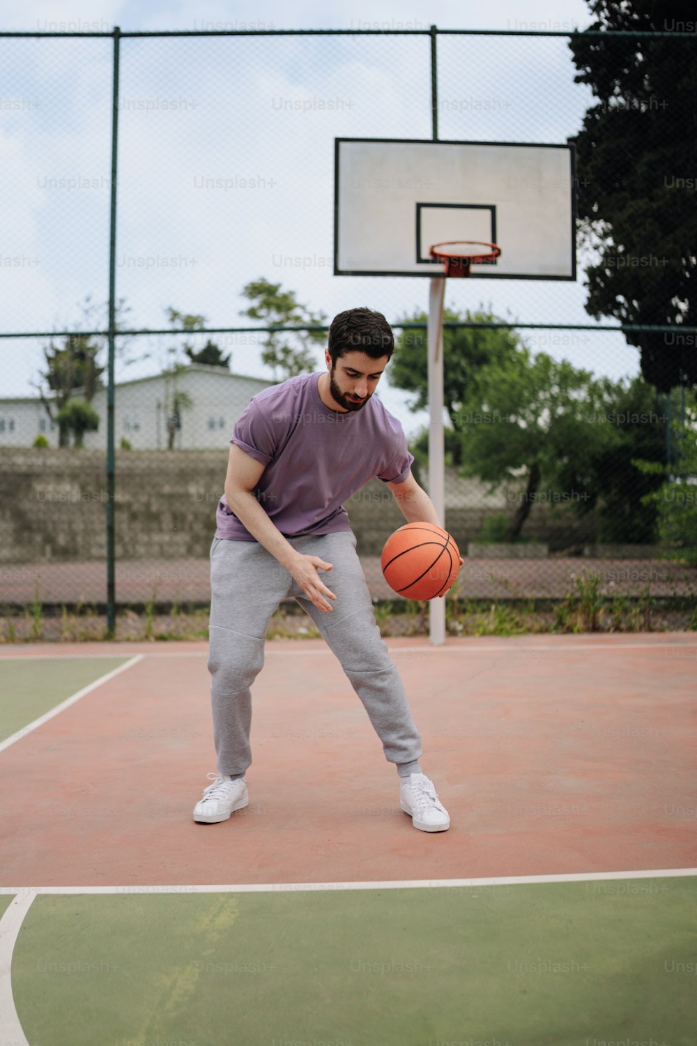 a man holding a basketball on top of a basketball court