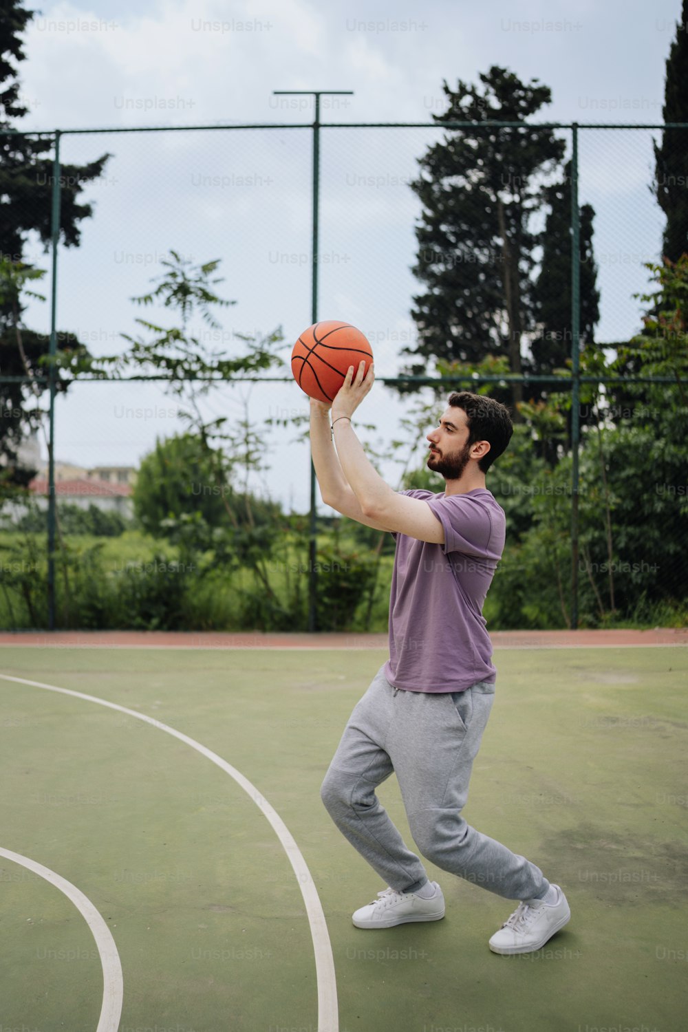 a man holding a basketball on top of a basketball court