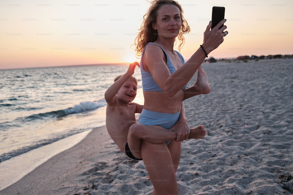 Una mujer sosteniendo a un niño en la playa