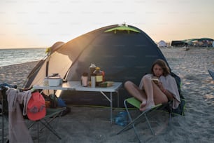 a woman sitting in a chair in front of a tent