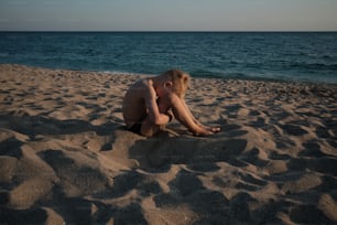 uma pessoa sentada na areia da praia