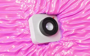 ein weißer Lautsprecher, der auf einer rosafarbenen Oberfläche sitzt