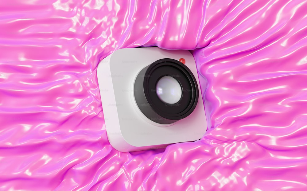 a white speaker sitting on top of a pink surface