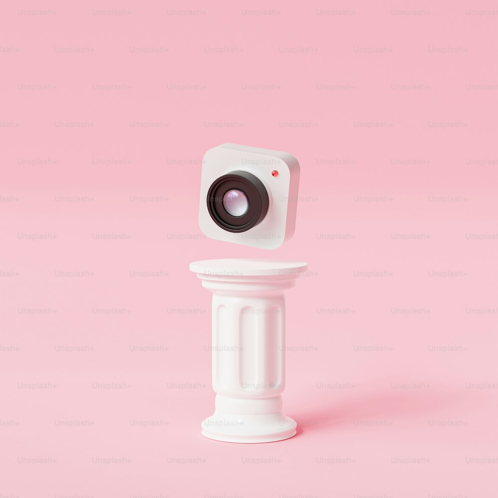 a small camera sitting on top of a white pedestal