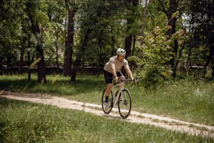 a man riding a bike down a dirt road