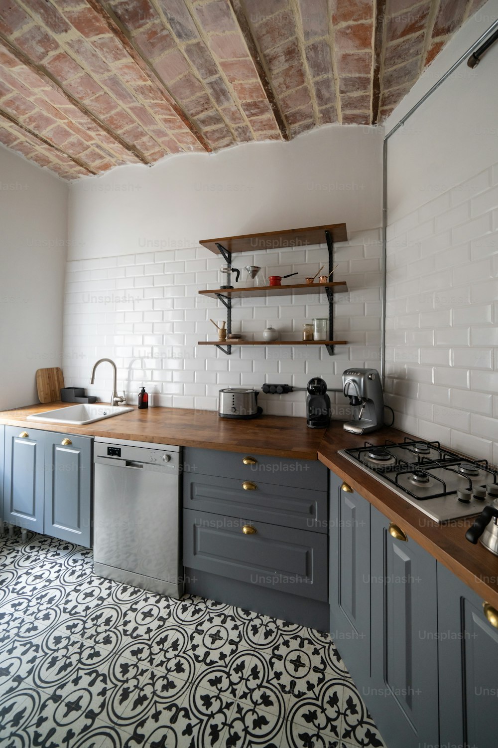 a kitchen with a stove top oven sitting under a brick ceiling