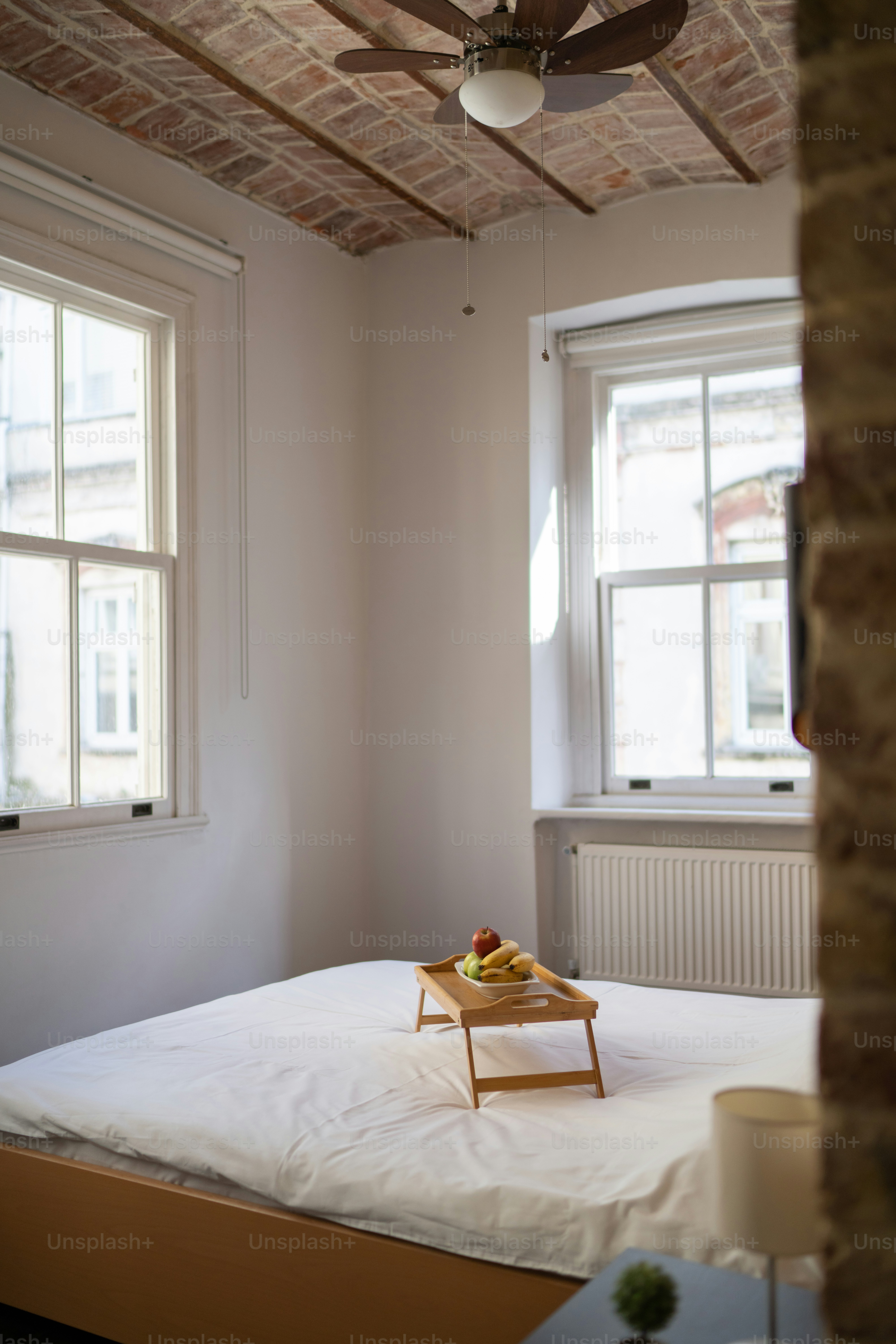 ein Bett mit einem Tablett mit Obst darauf
