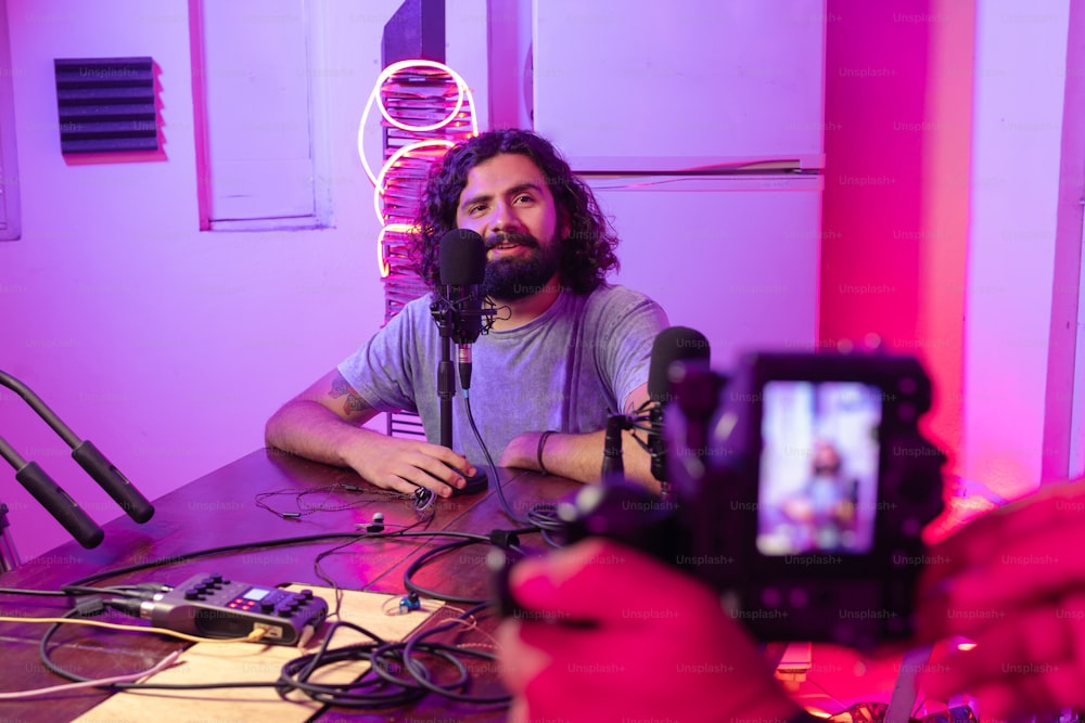 a man sitting at a table in front of a microphone