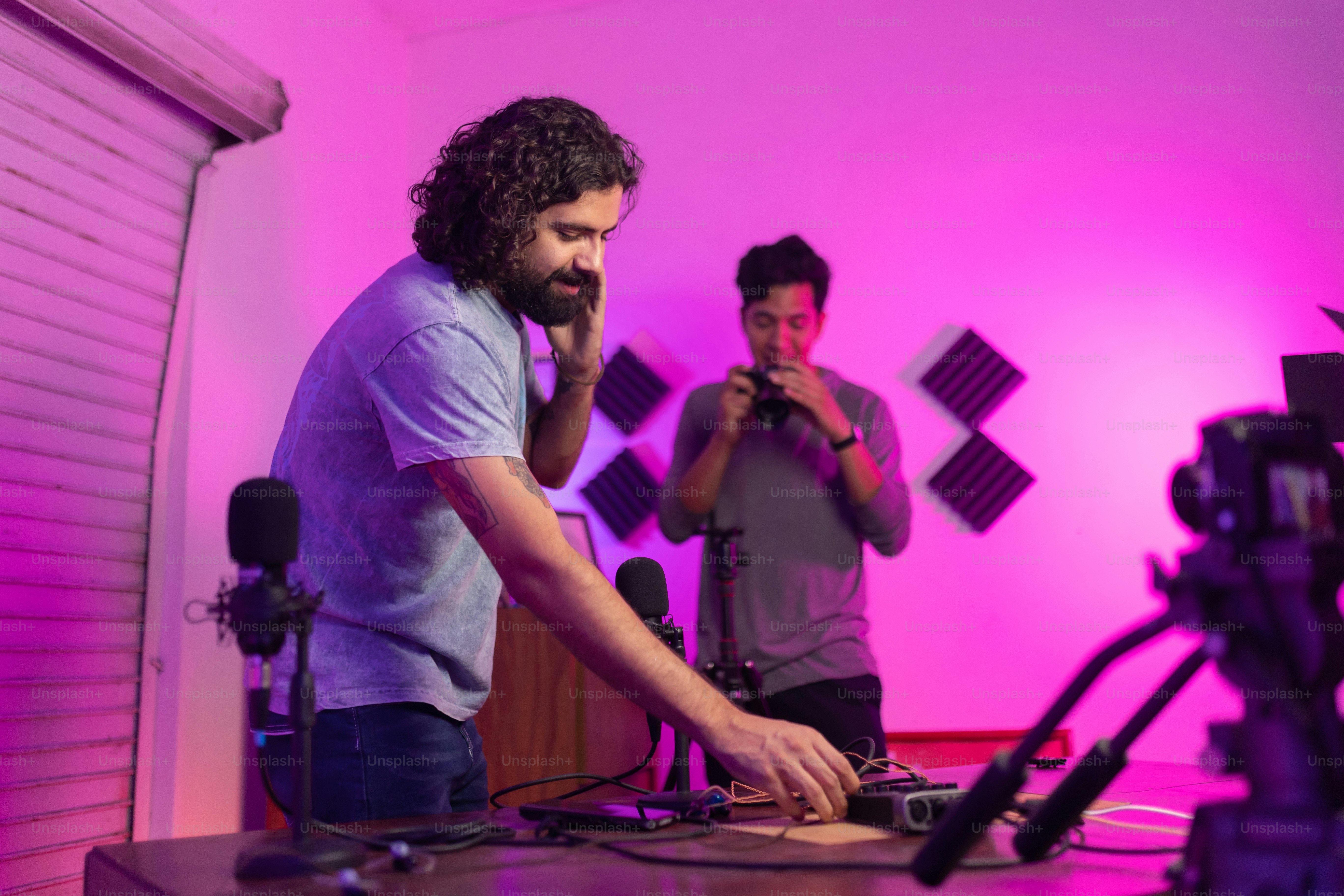 a couple of men standing in front of a camera