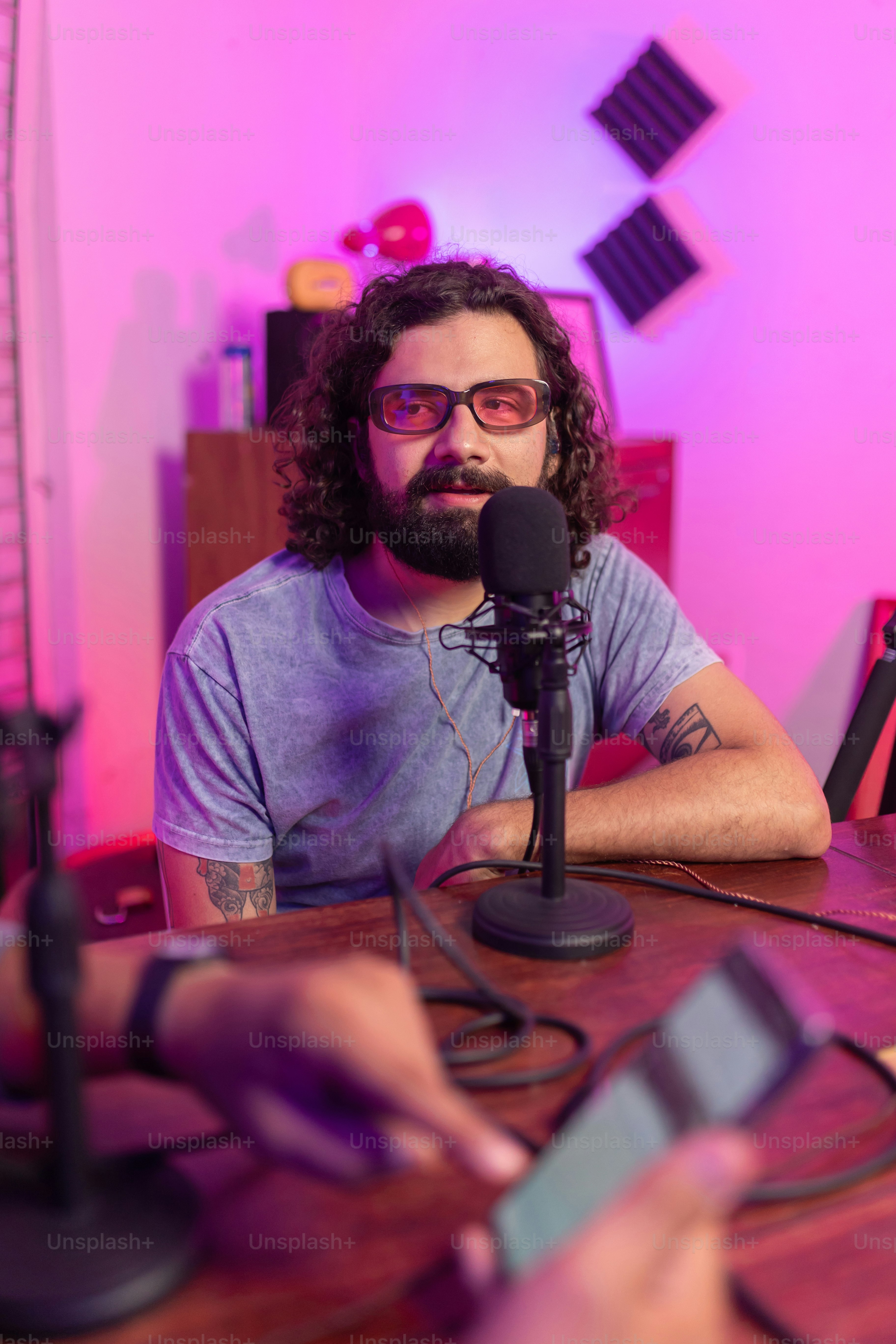 a man sitting at a table in front of a microphone