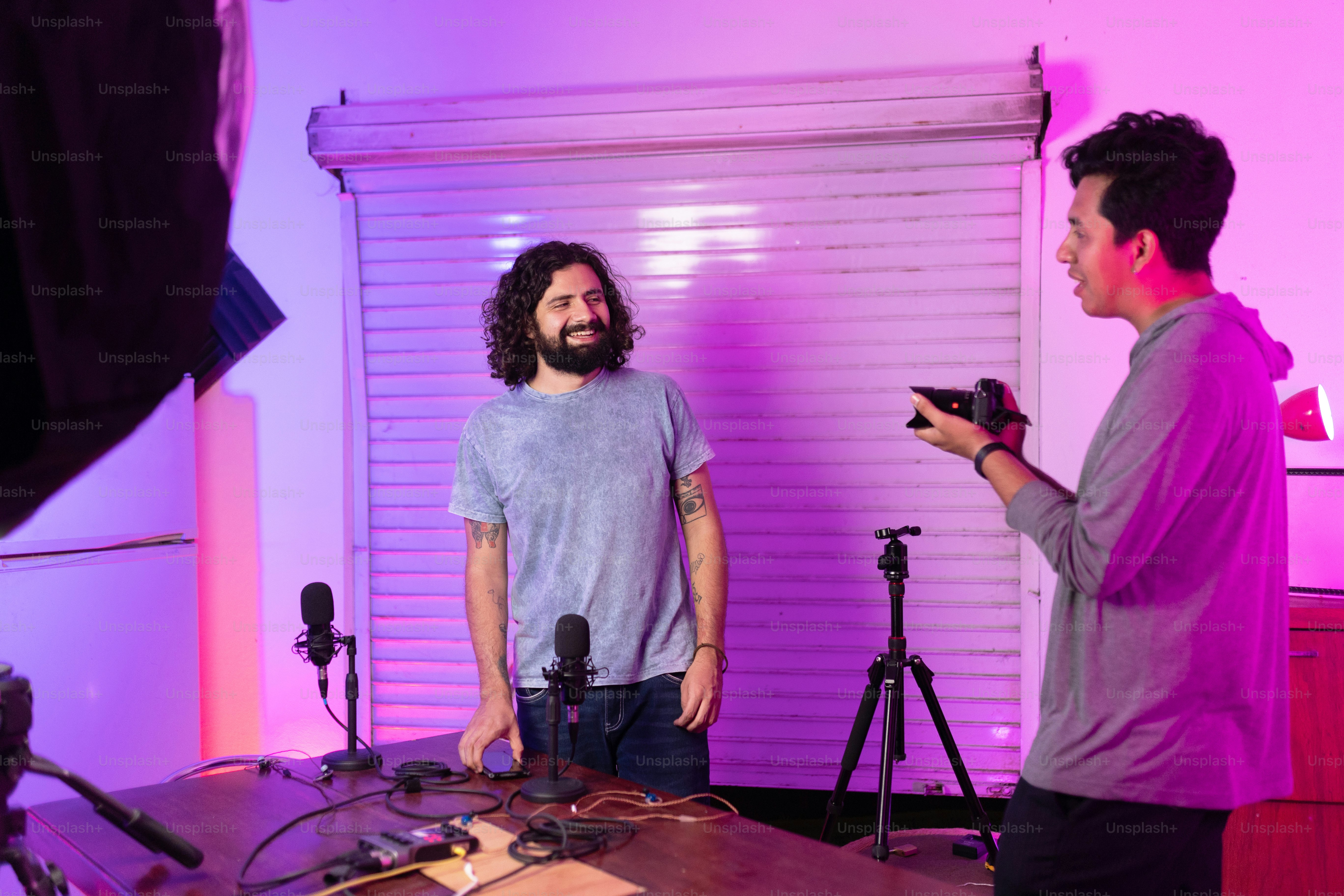 a man standing in front of a camera next to another man