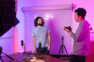 a man standing in front of a camera next to another man