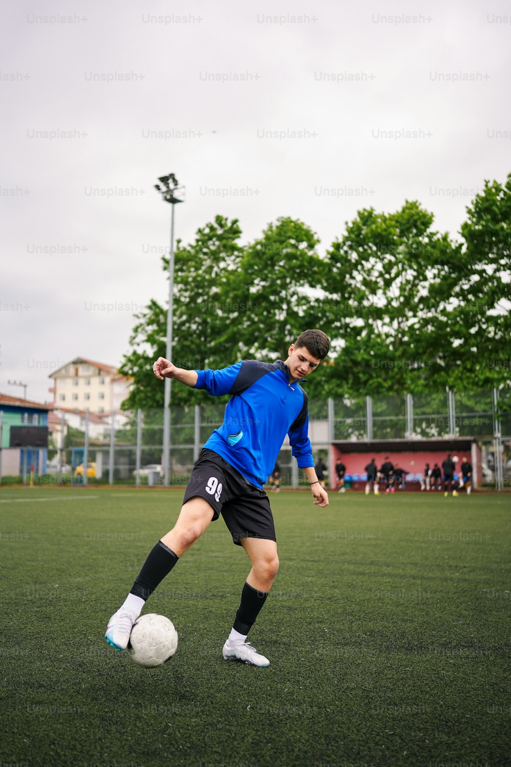 a young man kicking a soccer ball on a field