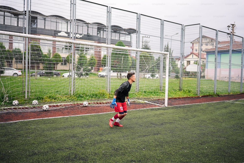 um menino jogando futebol em um campo de futebol