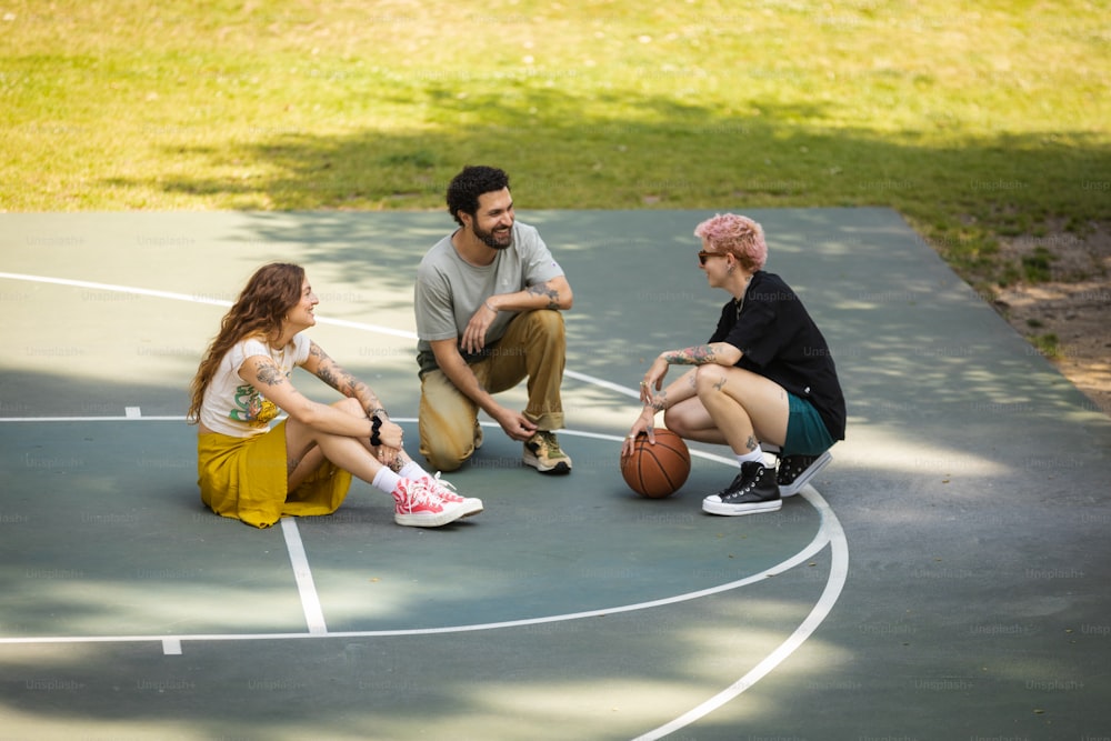 a group of people sitting on a basketball court
