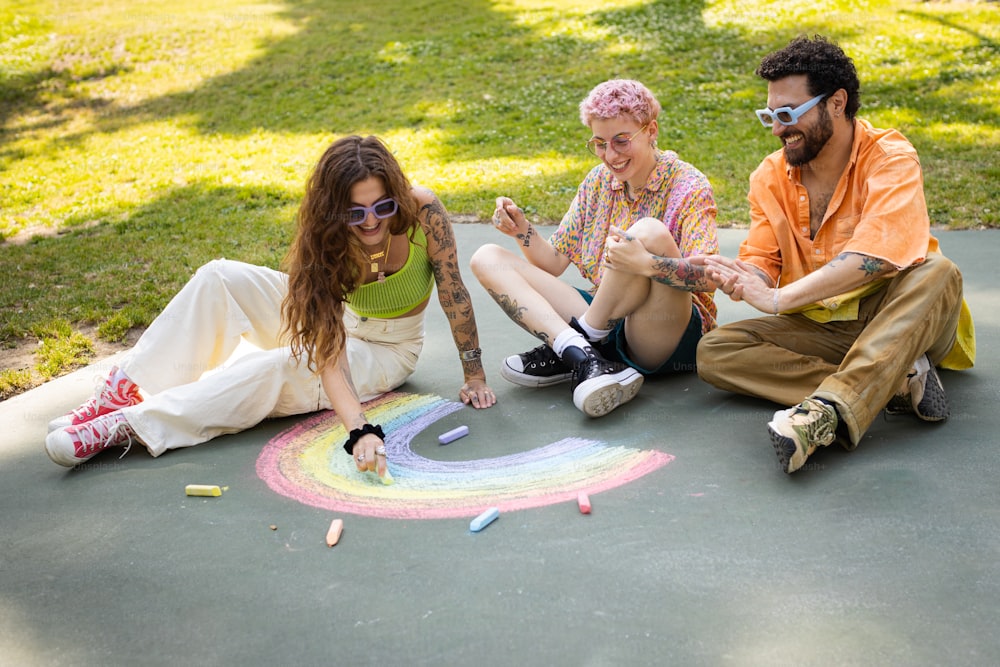 eine gruppe von menschen, die auf dem boden sitzen und einen regenbogen zeichnen